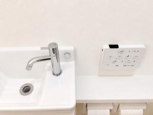 a bathroom with a sink and a clock on the wall at Nakijin Terrace in Nakijin +31 photos