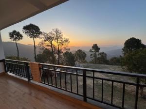 a balcony of a house with a view of the mountains at The Kalindi's Resort, Almora in Almora +21 photos