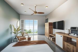 a bedroom with a bed and a tv and a couch at SUWA CHANDU - By Mountain Boutiques Luxury Collection in Mirissa