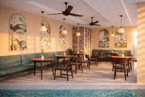 a restaurant with tables and chairs and a pool at SUWA CHANDU - By Mountain Boutiques Luxury Collection in Mirissa