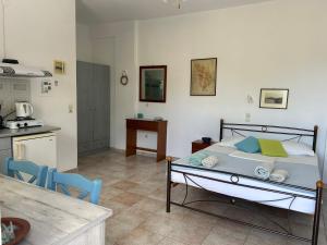 a bedroom with a bed and a kitchen at Villa Costa Studios in Vathi