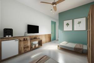 a bedroom with a bed and a flat screen tv at SUWA CHANDU - By Mountain Boutiques Luxury Collection in Mirissa