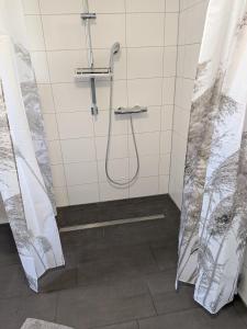 a shower with a shower curtain in a bathroom at Pfoten & Komfort Barrierefrei in Butjadingen +12 photos