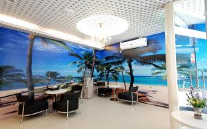 Happiness Inn في تايبيه: مطعم بطاولات وكراسي وجدارية للشاطئ