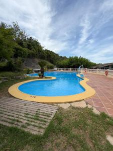 a large swimming pool with a yellow curb around it at La Somavan Tambu in Xàtiva