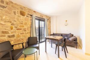 a living room with a brick wall and a table and chairs at Shire Küçükköy in Ayvalık