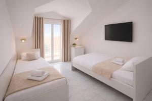 a bedroom with two beds and a flat screen tv at All inclusive Villa Four Pearls in Trogir