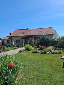a house with a yard with flowers and plants at Dworek in Swarzewo