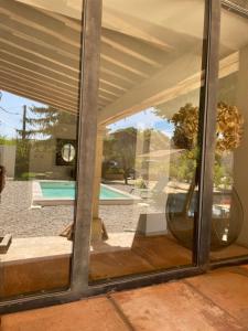 a window of a house with a view of a pool at La Bastide Chamarrée in Camaret-sur-Aigues +7 photos