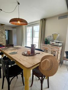a table in a kitchen with chairs and a dining room at La Bastide Chamarrée in Camaret-sur-Aigues