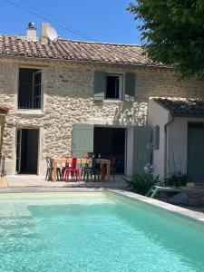 a house with a swimming pool in front of a house at La Bastide Chamarrée in Camaret-sur-Aigues