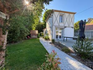 a garden with a house and a bench in the yard at Maison proche Disney & Paris in Lagny