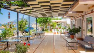 a patio with tables and chairs and windows at Kas Maki Hotel in Kaş