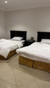 two beds sitting in a room with at زهرة الهدا in Al Hada