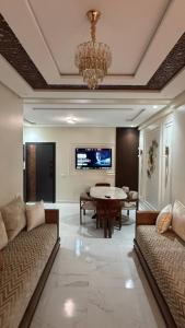 a living room with a chandelier and a couch and a table at Modern flat in a central location in Kenitra in Kenitra