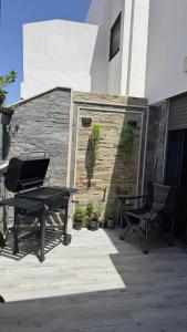 a black piano and a chair on a patio at Modern flat in a central location in Kenitra in Kenitra