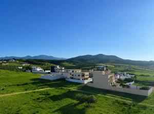 an aerial view of a village with mountains in the background at Paraiso Costero Azla Tetouan in Azla