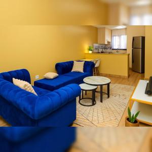 a living room with a blue couch and a table at Shwari Home Stays in Kisii