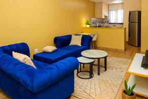 a living room with a blue couch and a table at Shwari Home Stays in Kisii +9 photos
