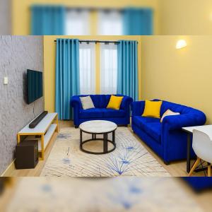 a living room with two blue couches and a table at Shwari Home Stays in Kisii