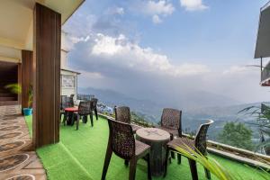 a balcony with chairs and a table and a view at Valley Vista Rooms l Restaurant and Cafe l Forest Treks l Kufri by Exotic Stays in Kūfrī +12 photos