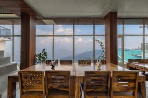a dining room with a table and a large window at Valley Vista Rooms l Restaurant and Cafe l Forest Treks l Kufri by Exotic Stays in Kūfrī