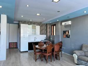 a kitchen and dining room with a table and chairs at Host Apartments in Shkodër