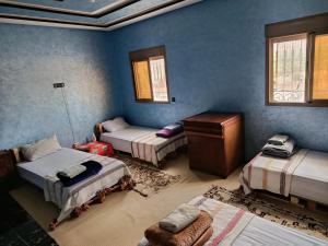 a room with three beds and a chair in it at Jnan Narjiss atlas in Asni