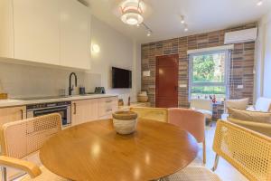 a kitchen and dining room with a wooden table and chairs at Happy Cactus 1BR Apartment In Batroun Souks in Batroûn
