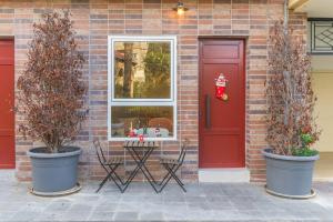 a red door and two potted trees in front of a house at Happy Cactus 1BR Apartment In Batroun Souks in Batroûn