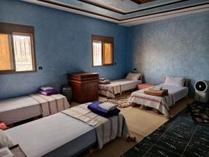 a room with four beds in a room at Jnan Narjiss atlas in Asni