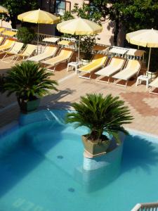einen Pool mit Liegestühlen und Sonnenschirmen und einem sidx sidx sidx in der Unterkunft Casa Cressotti appartamenti in Malcesine