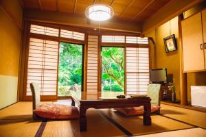 a room with a table and chairs and a window at Tanakaya in Kurobe