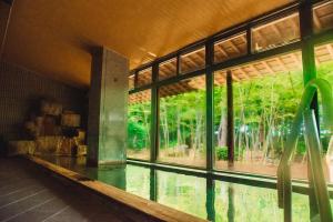 a room with a pool of water and a large window at Tanakaya in Kurobe