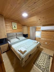 a bedroom with a bed in a wooden cabin at Nana Dea in Utjeha