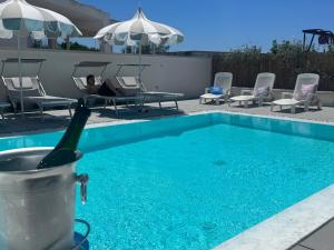 a person sitting in a chair next to a swimming pool at Vistamare - Bed & Breakfast in Alliste
