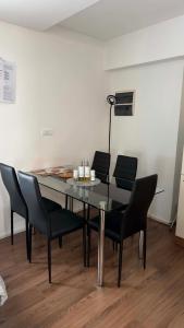 a dining room table with black chairs and a lamp at Apartma SAAAN in Šempas