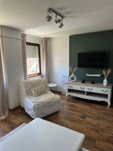 a living room with a couch and a flat screen tv at Daddy's home in Hargesheim