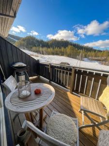 a wooden deck with a table and chairs on it at Alpintunet Uvdal in Sønstebø