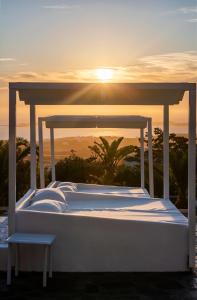 a bed with the sunset in the background at Chrysalis Nature Villa 8 in Kampos Paros +62 photos
