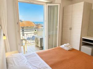 a bedroom with a bed and a view of the ocean at Hotel Degli Angeli Riccione in Riccione