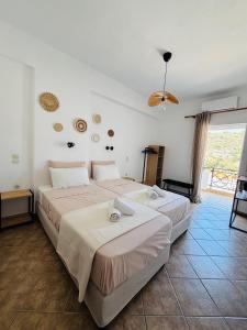 ein Schlafzimmer mit zwei Betten und einem großen Fenster in der Unterkunft Happy Days in Agia Galini