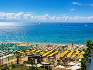 a beach with a lot of umbrellas and the ocean at Hotel Degli Angeli Riccione in Riccione +37 photos