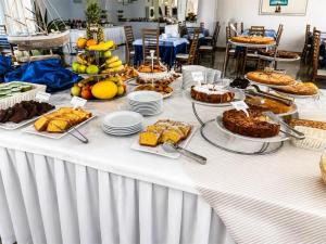 a table with desserts and cakes on top of it at Hotel Degli Angeli Riccione in Riccione