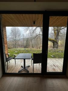 a room with a table and a bench and a window at Apartman Jasan Spot in Železná Ruda