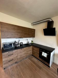 a kitchen with wooden cabinets and a microwave at Apartman Jasan Spot in Železná Ruda +11 photos