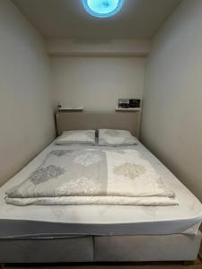 a bed in a small room with a blue light at Apartman Jasan Spot in Železná Ruda
