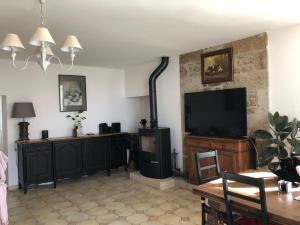 a living room with a flat screen tv on a wall at Le Logis du GAST Chambre Taupe in Le Gast