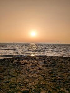 a sunset over the ocean with the sun setting at Ferienwohnung "Pfoten & Komfort" in Butjadingen