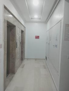 a hallway with white walls and a hallway with doors at Nozeht el soltan in Potinville +3 photos